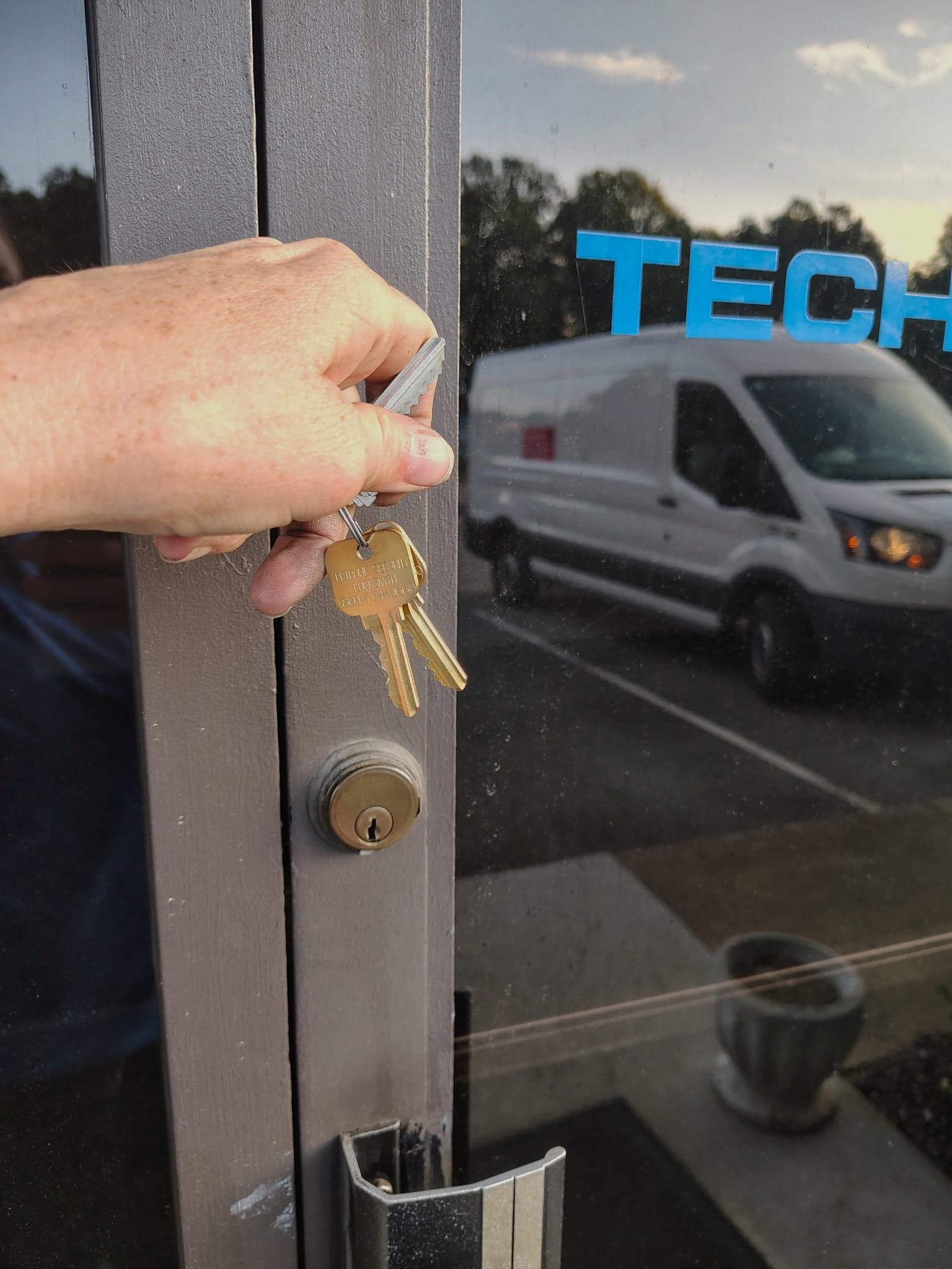 Mary Petrone with keys in front of storefront - professional locksmith services